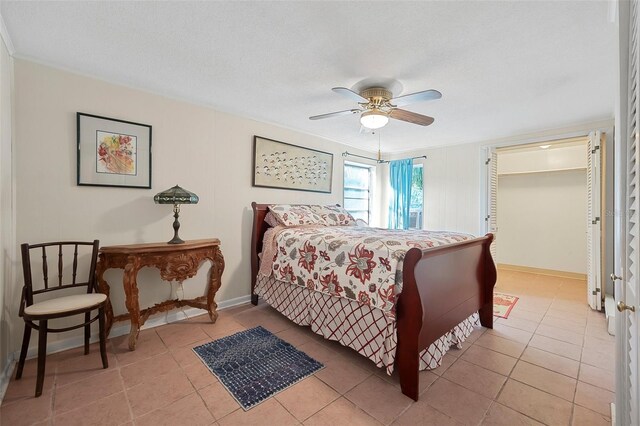 61 E Bayshore Dr, Port Orange, FL 32127 - bedroom with ceiling fan, light tile patterned floors, a textured ceiling, and baseboards