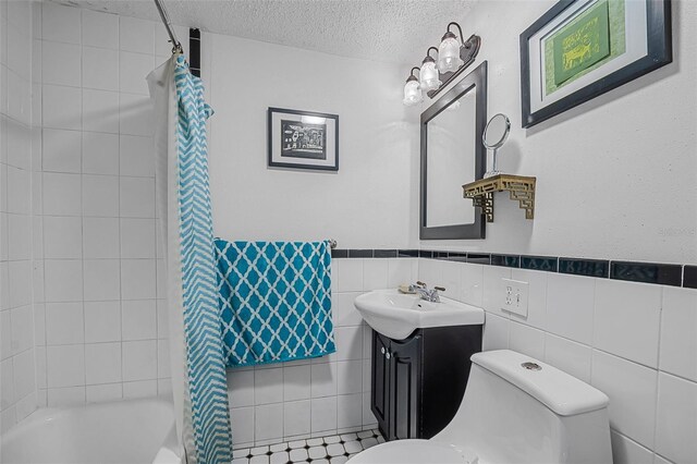 61 E Bayshore Dr, Port Orange, FL 32127 - full bathroom with toilet, a textured ceiling, vanity, shower / bath combination with curtain, and wainscoting