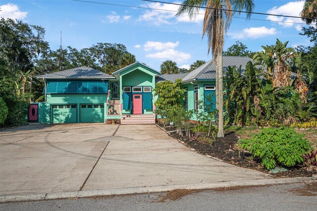 61 E Bayshore Dr, Port Orange, FL 32127 - view of front of home featuring concrete driveway, a garage, and metal roof