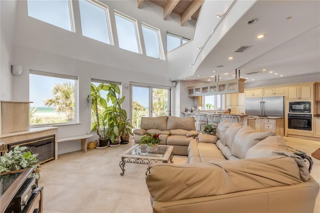 1209 N Atlantic Ave, New Smyrna Beach, FL 32169 - living area featuring a high ceiling, beamed ceiling, recessed lighting, and light tile patterned floors