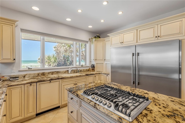 1209 N Atlantic Ave, New Smyrna Beach, FL 32169 - kitchen featuring cream cabinetry, appliances with stainless steel finishes, light stone counters, and recessed lighting