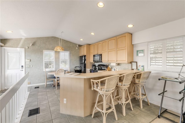 1209 N Atlantic Ave, New Smyrna Beach, FL 32169 - kitchen featuring light brown cabinets, baseboards, wallpapered walls, vaulted ceiling, and black appliances