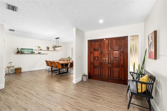 4301 Hudson Ln, Tampa, FL 33618 - entryway with light wood-style flooring, baseboards, and a textured ceiling