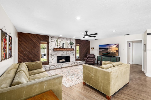 4301 Hudson Ln, Tampa, FL 33618 - living area with a ceiling fan, wood finished floors, a stone fireplace, recessed lighting, and wooden walls