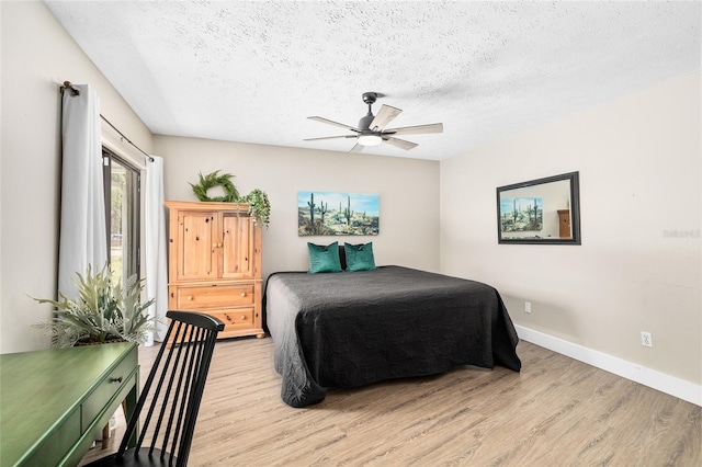 4301 Hudson Ln, Tampa, FL 33618 - bedroom featuring light wood-style floors, a textured ceiling, baseboards, and a ceiling fan