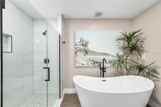 4301 Hudson Ln, Tampa, FL 33618 - bathroom with a stall shower, a soaking tub, baseboards, and wood finished floors