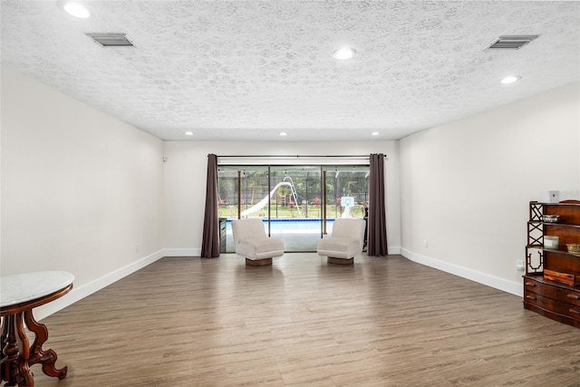 4301 Hudson Ln, Tampa, FL 33618 - sitting room featuring wood finished floors, a textured ceiling, baseboards, and recessed lighting