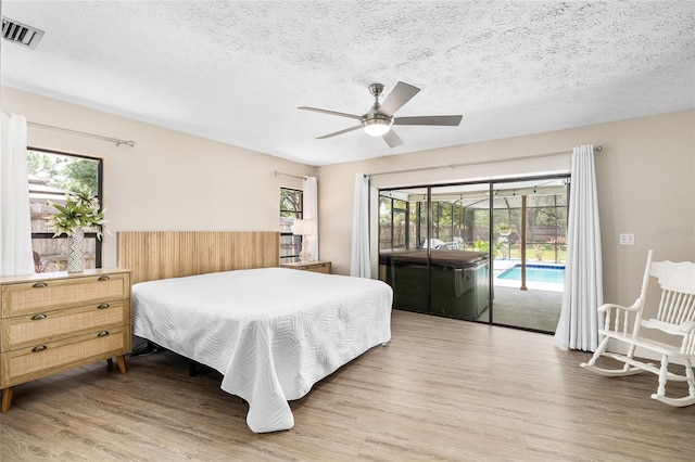 4301 Hudson Ln, Tampa, FL 33618 - bedroom with access to exterior, wood finished floors, a textured ceiling, multiple windows, and ceiling fan