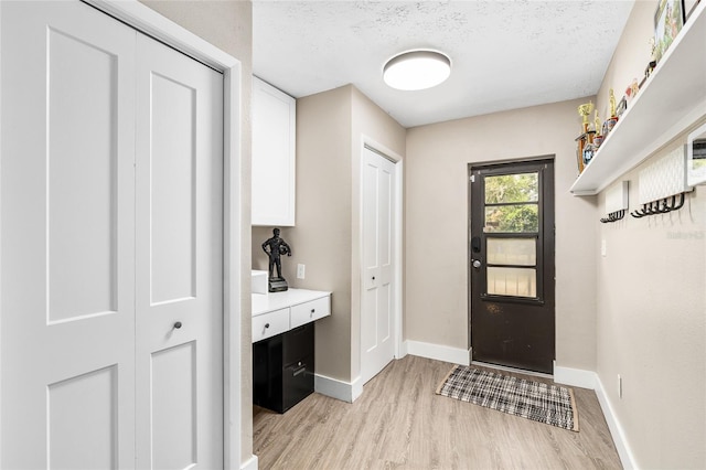 4301 Hudson Ln, Tampa, FL 33618 - entrance foyer featuring light wood-style flooring, baseboards, and a textured ceiling