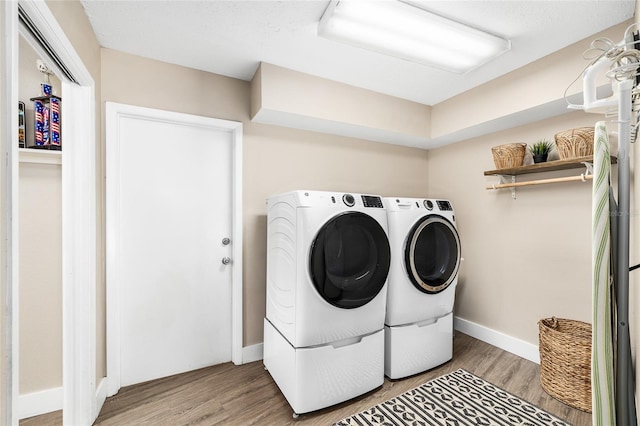 4301 Hudson Ln, Tampa, FL 33618 - laundry room featuring washing machine and clothes dryer, light wood finished floors, and baseboards