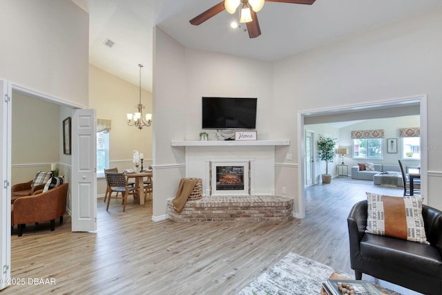 706 Fox Tail Ct, New Smyrna Beach, FL 32168 - living area featuring high vaulted ceiling, wood finished floors, ceiling fan, a chandelier, and a brick fireplace
