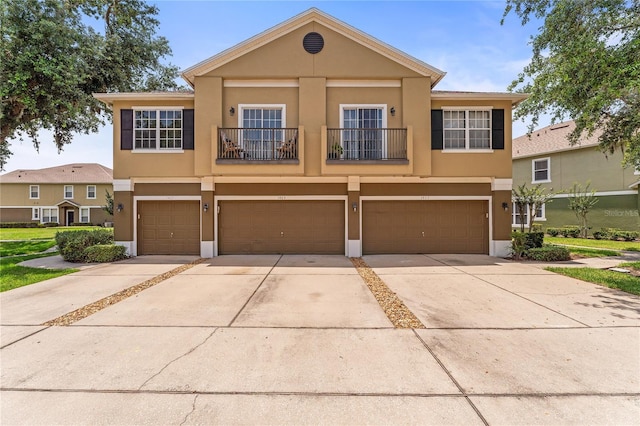 1469 Broken Oak Dr Unit 43A, Winter Garden, FL 34787 - view of property with stucco siding, concrete driveway, a garage, and a balcony
