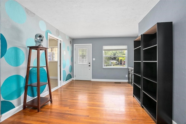 45 S University Cir, Deland, FL 32724 - entryway featuring wood finished floors, a textured ceiling, and baseboards