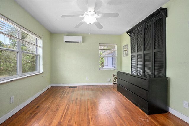 45 S University Cir, Deland, FL 32724 - unfurnished bedroom featuring a wall mounted air conditioner, hardwood / wood-style flooring, and baseboards