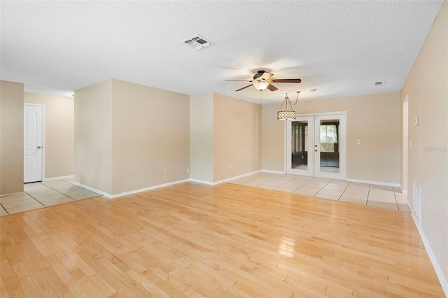 1204 Lawrence Ave, Deltona, FL 32725 - spare room with light wood-style floors, ceiling fan, baseboards, french doors, and a textured ceiling