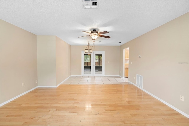 1204 Lawrence Ave, Deltona, FL 32725 - spare room featuring a ceiling fan, light wood-style floors, a textured ceiling, baseboards, and french doors
