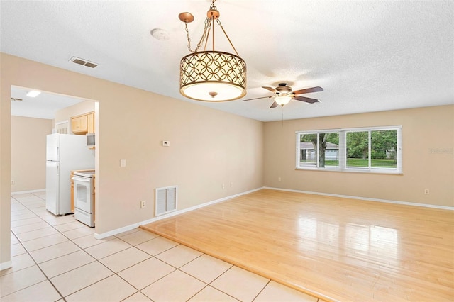1204 Lawrence Ave, Deltona, FL 32725 - unfurnished room with ceiling fan, baseboards, light tile patterned floors, and a textured ceiling