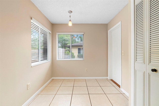 1204 Lawrence Ave, Deltona, FL 32725 - unfurnished dining area featuring a textured ceiling, baseboards, and light tile patterned floors