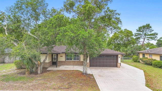 1204 Lawrence Ave, Deltona, FL 32725 - view of front of house featuring a garage, driveway, a shingled roof, and brick siding