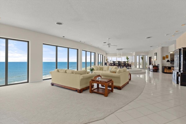 915 Ocean Shore Blvd Unit 8010, Ormond Beach, FL 32176 - tiled living room featuring a textured ceiling, a water view, ceiling fan, and carpet floors