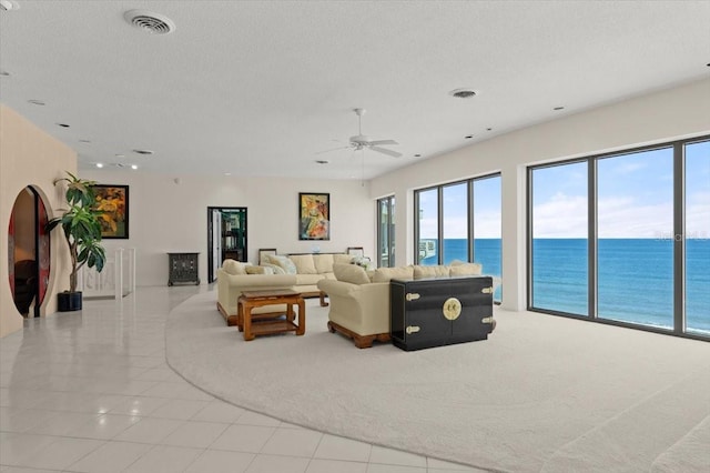915 Ocean Shore Blvd Unit 8010, Ormond Beach, FL 32176 - carpeted living room featuring a water view, a ceiling fan, tile patterned flooring, a textured ceiling, and recessed lighting