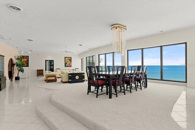 915 Ocean Shore Blvd Unit 8010, Ormond Beach, FL 32176 - dining room with tile patterned flooring, a textured ceiling, a water view, carpet, and a ceiling fan
