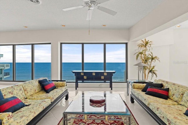 915 Ocean Shore Blvd Unit 8010, Ormond Beach, FL 32176 - living room featuring a water view, a textured ceiling, healthy amount of natural light, light tile patterned floors, and ceiling fan