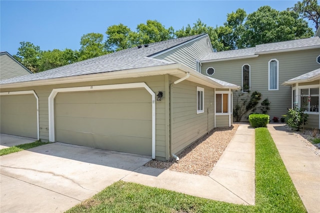 15 Misners Trl, Ormond Beach, FL 32174 - view of property exterior featuring driveway, an attached garage, and roof with shingles