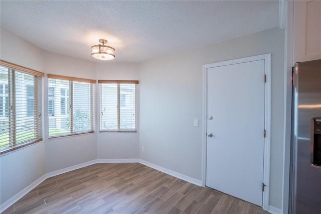 15 Misners Trl, Ormond Beach, FL 32174 - unfurnished dining area with healthy amount of natural light, light wood finished floors, and a textured ceiling