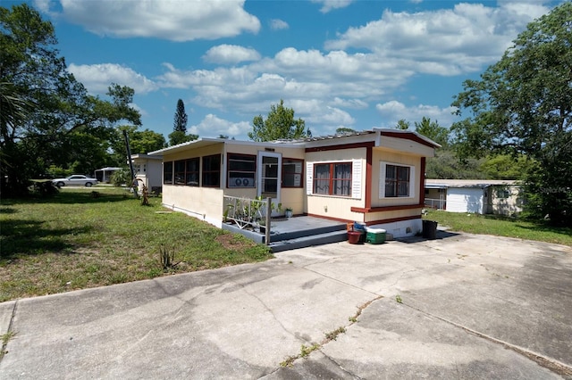 487 Collins St, Ormond Beach, FL 32174 - view of front of home with a front yard and a sunroom