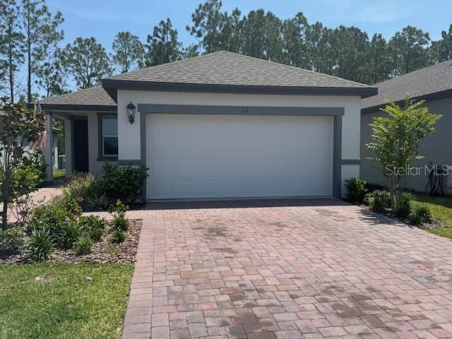 112 Lost Ball Dr, Daytona Beach, FL 32124 - single story home featuring decorative driveway, roof with shingles, an attached garage, and stucco siding