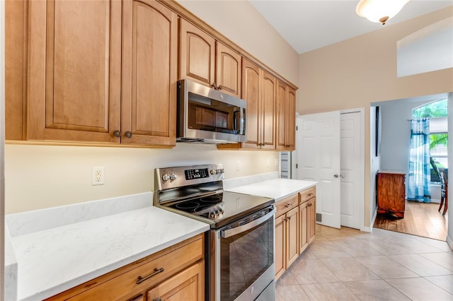 1910 Creekwater Blvd, Port Orange, FL 32128 - kitchen with stainless steel appliances, light tile patterned floors, and light stone countertops
