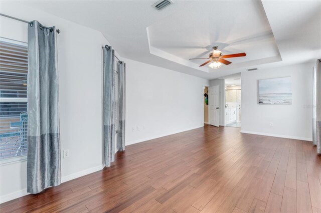 1910 Creekwater Blvd, Port Orange, FL 32128 - spare room featuring a tray ceiling, a ceiling fan, wood finished floors, and baseboards
