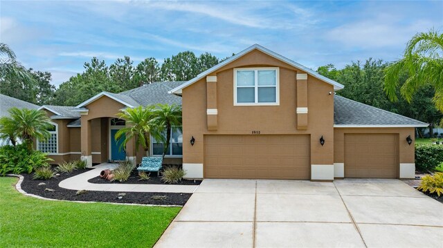 1910 Creekwater Blvd, Port Orange, FL 32128 - view of front facade with stucco siding, driveway, a shingled roof, and a garage