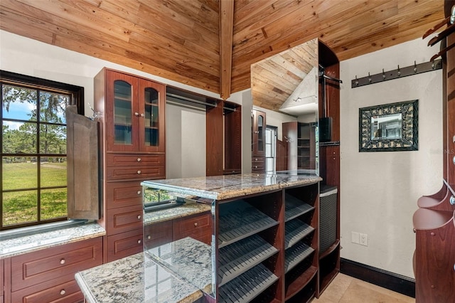 5366 N Lake Farms Rd, De Leon Springs, FL 32130 - kitchen with wood ceiling, glass insert cabinets, light stone counters, light tile patterned floors, and vaulted ceiling