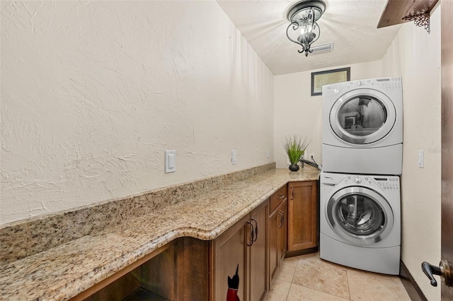 5366 N Lake Farms Rd, De Leon Springs, FL 32130 - washroom featuring stacked washer / drying machine, cabinet space, and a textured wall