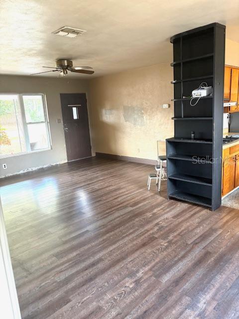 3 Cassia Ln, Debary, FL 32713 - unfurnished living room featuring dark wood finished floors, ceiling fan, and baseboards