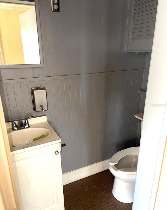 3 Cassia Ln, Debary, FL 32713 - bathroom featuring toilet, vanity, tile walls, a wainscoted wall, and tile patterned flooring