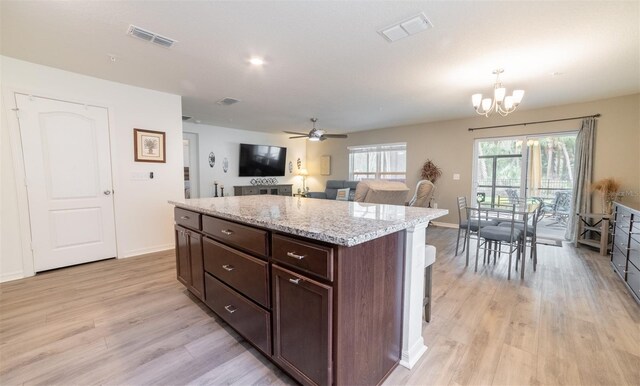 1671 Pecorino Ct, Titusville, FL 32780 - kitchen featuring light wood finished floors, a chandelier, baseboards, a ceiling fan, and a kitchen island