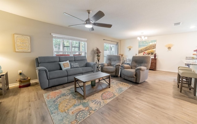 1671 Pecorino Ct, Titusville, FL 32780 - living room with ceiling fan, a chandelier, light wood-style flooring, and baseboards