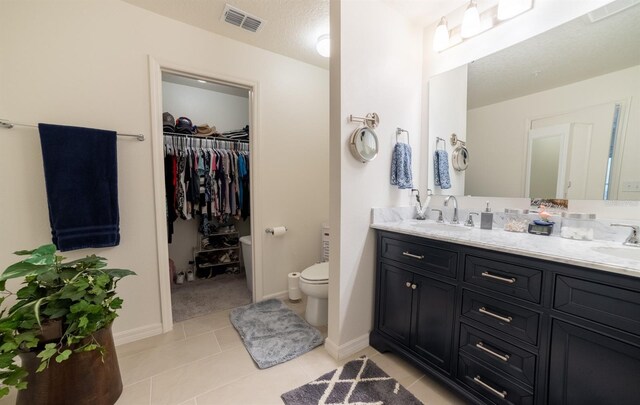 1671 Pecorino Ct, Titusville, FL 32780 - bathroom with double vanity, toilet, tile patterned floors, a walk in closet, and baseboards