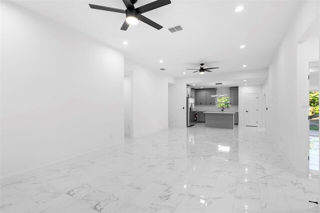 1163 W Hancock Dr, Deltona, FL 32725 - unfurnished living room featuring ceiling fan, recessed lighting, healthy amount of natural light, and light marble finish floors