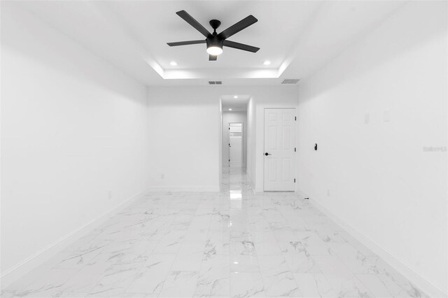 1163 W Hancock Dr, Deltona, FL 32725 - empty room with a raised ceiling, recessed lighting, ceiling fan, and light marble finish floors