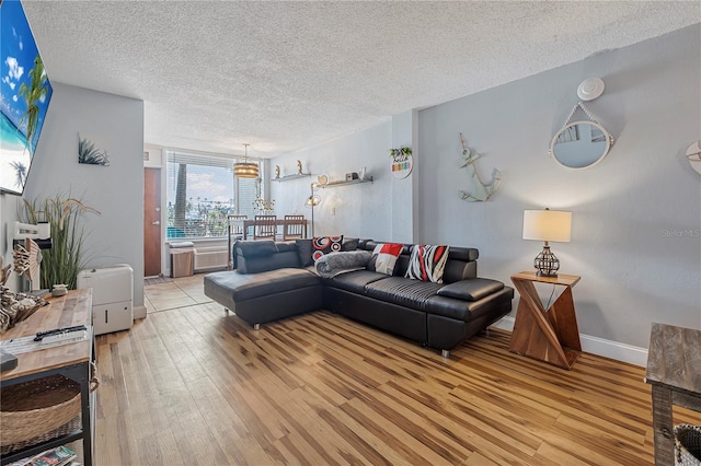 935 S Atlantic Ave Unit 105, Daytona Beach, FL 32118 - living room with light wood-type flooring, a textured ceiling, a chandelier, and baseboards