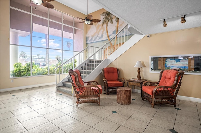935 S Atlantic Ave Unit 105, Daytona Beach, FL 32118 - tiled living room featuring ceiling fan, stairway, track lighting, healthy amount of natural light, and a textured ceiling