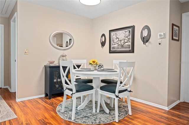 dining space with wood finished floors and baseboards