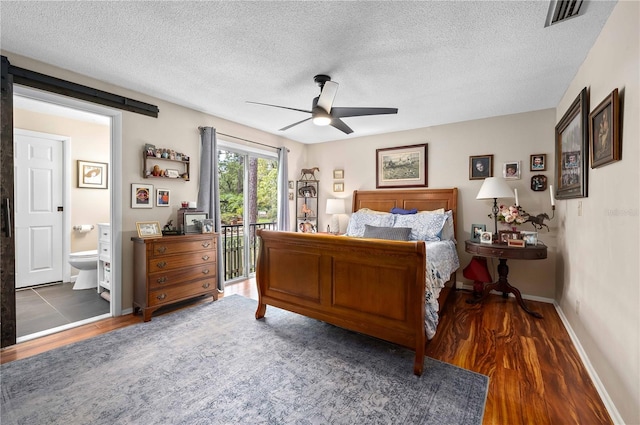 bedroom with wood finished floors, access to outside, a textured ceiling, baseboards, and ensuite bath