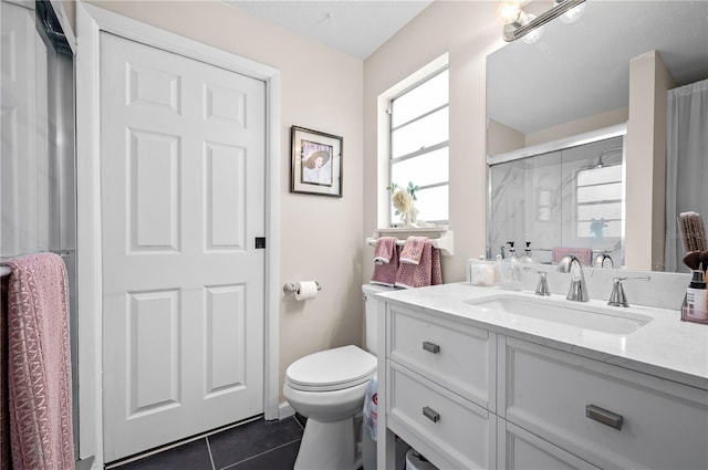 full bathroom with vanity, a shower stall, tile patterned flooring, and toilet