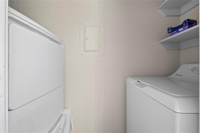 washroom with washing machine and clothes dryer and electric panel