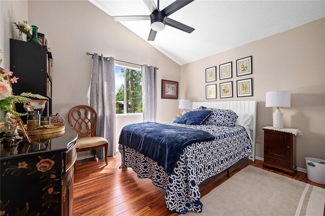 bedroom featuring vaulted ceiling, wood finished floors, a ceiling fan, and baseboards